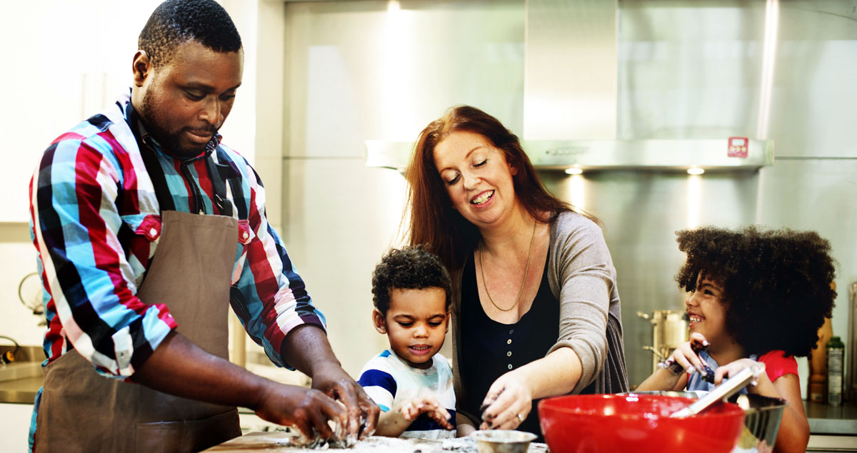 Image of parents and two children baking in the kitchen