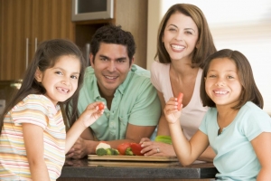 Image of family smiling eating vegetables